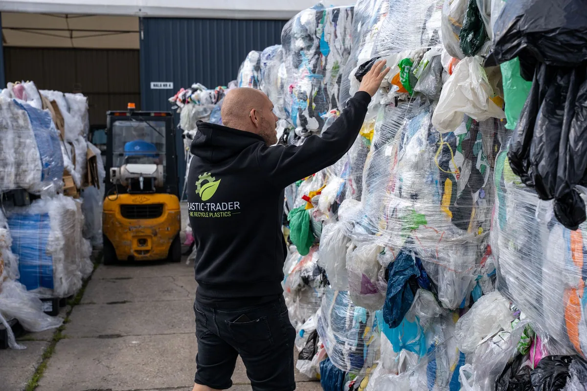 Pracownik Plastic Trader sprawdza bele odpadów plastikowych przygotowane do skupu na placu zakładu w Cieszynie